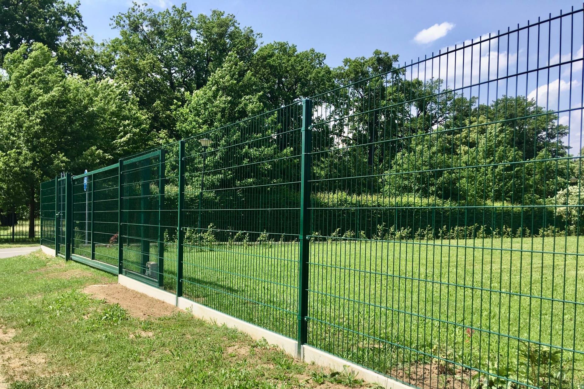 Zelené panelové oplocení 3D v parku — realizace Stavíme ploty