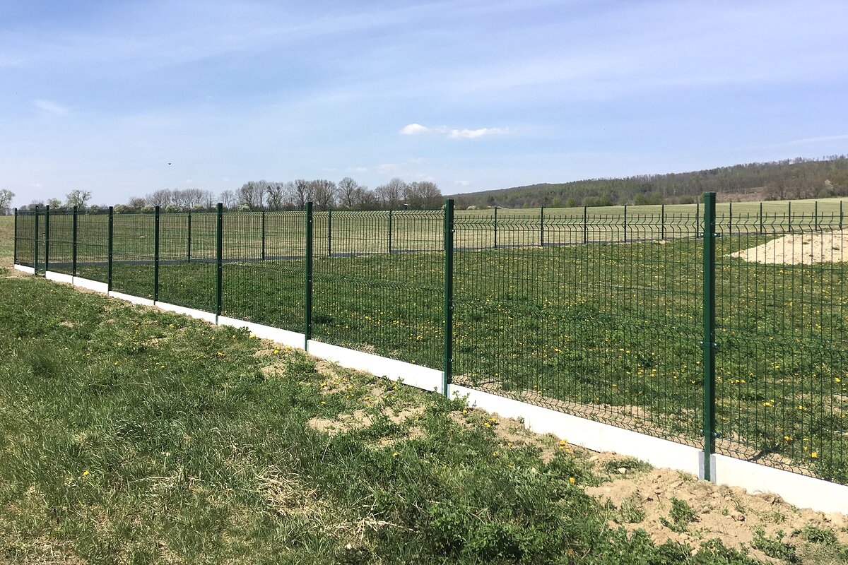 Zelené panelové oplocení 3D s podhrabovými deskami u pole